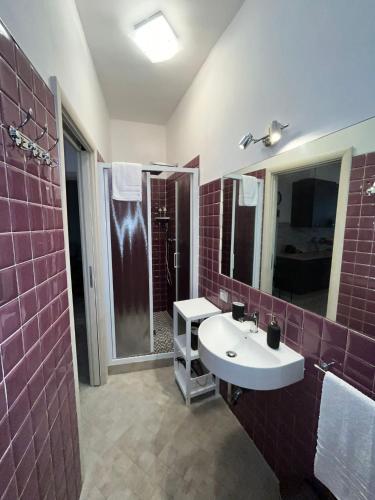 La salle de bains est pourvue d'un lavabo et d'un grand miroir. dans l'établissement Casa Valeria, à Tuscania