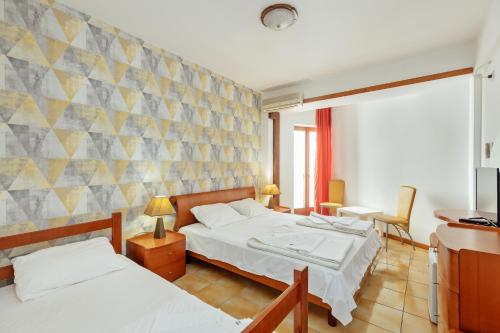 a hotel room with two beds and a tv at Depadans Hotela TALIA in Igalo