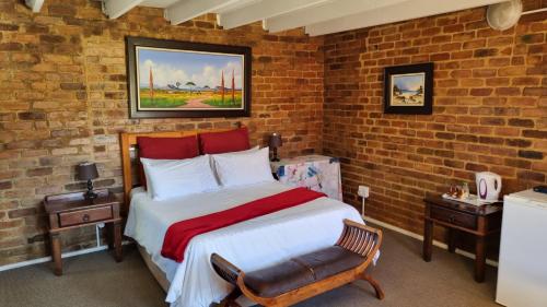 sypialnia z łóżkiem i ceglaną ścianą w obiekcie Angel's mist guesthouse w mieście Kaapsehoop