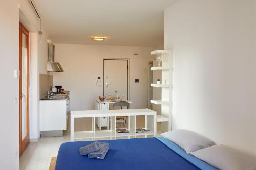 una camera con letto blu e una cucina di Moderno Monolocale in Città con Parcheggio privato a Civitanova Marche