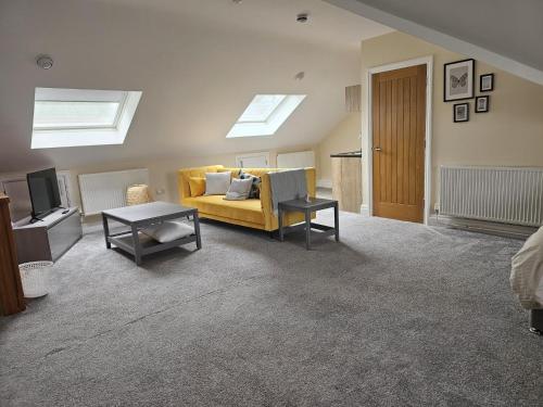 a living room with a yellow couch and a table at 1 Bed Loft - Sleeps 2 - Parking - Wifi in Newport