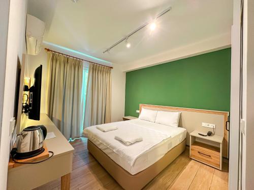 a bedroom with a bed and a green wall at Club Sema Suite Hotel in Marmaris