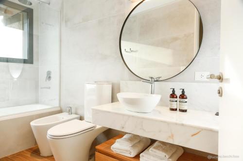 a white bathroom with a sink and a mirror at Kaulem Hotel Boutique in El Chalten