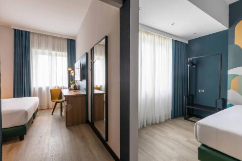 um quarto de hotel com duas camas e uma secretária em Belstay Roma Aurelia em Roma