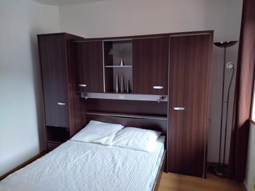 勒邦儂的住宿－Gîte Lion d'Or，一间卧室配有一张床和一个木制橱柜
