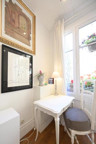 une table blanche et une chaise dans une chambre avec fenêtre dans l'établissement Villa d'art - Claire, à Paris