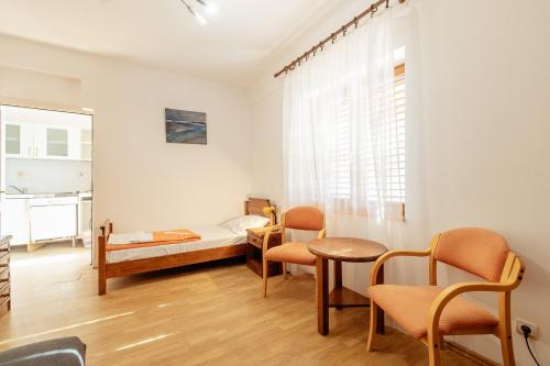 a room with a bed and a table and chairs at Depadans Hotela TALIA in Igalo