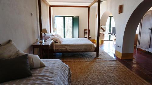 a bedroom with two beds and a table with a desk at Cortijo de Vega Grande in Llerena