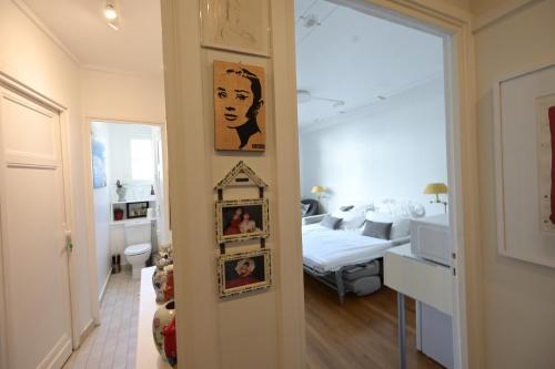 Cette chambre comprend un lit et des photos sur le mur. dans l'établissement Villa d'art - Claire, à Paris