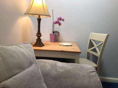 a desk with a lamp and a table with a chair at Railway Avenue Rooms in Clifden