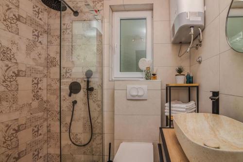 ein Bad mit einer Dusche und einem Waschbecken in der Unterkunft Studio Apartman Alexandra in Bakarac