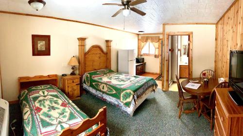 a bedroom with a bed and a desk and a table at Benzonia Rustic Resort in Benzonia