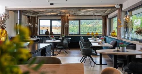um restaurante com mesas, cadeiras e janelas em Home suite home em Fieberbrunn