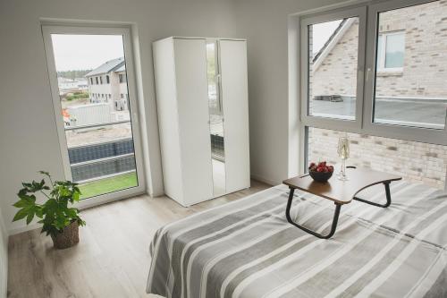 ein Wohnzimmer mit einem Tisch und großen Fenstern in der Unterkunft Heide Seele in Soltau