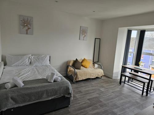 a bedroom with a bed and a couch and a table at Lovely Apartment in Swansea in Swansea