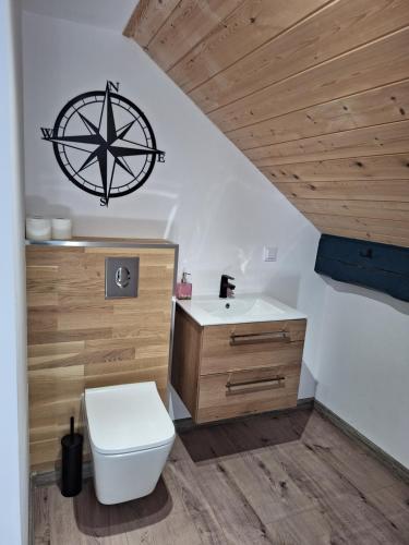 a bathroom with a white toilet and a sink at Apartamenty PRZYSTAŃ Chłopy in Chłopy