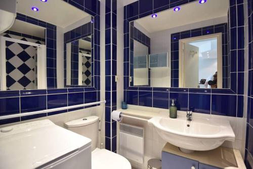 La salle de bains bleue et blanche est pourvue d'un lavabo et de toilettes. dans l'établissement Nice Signature Halévy, à Nice