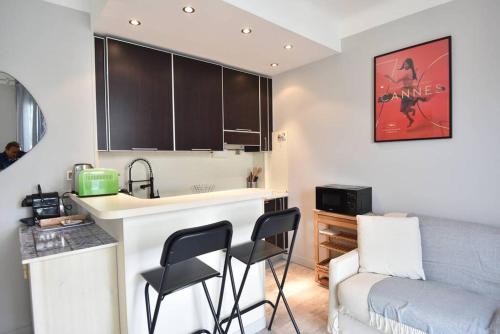 - une cuisine avec un comptoir et des chaises dans la chambre dans l'établissement Nice Signature Halévy, à Nice