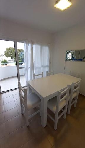 una mesa y sillas blancas en una habitación con ventana en 9 De Julio 345 en Puerto Madryn