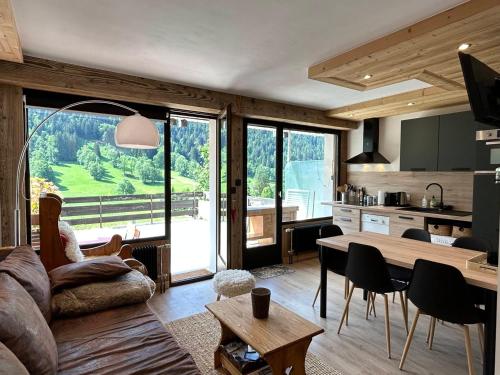 une cuisine et un salon avec une grande fenêtre dans l'établissement Charmant studio rénové à La Clusaz - 4 pers, terrasse, parking - FR-1-437-102, à La Clusaz