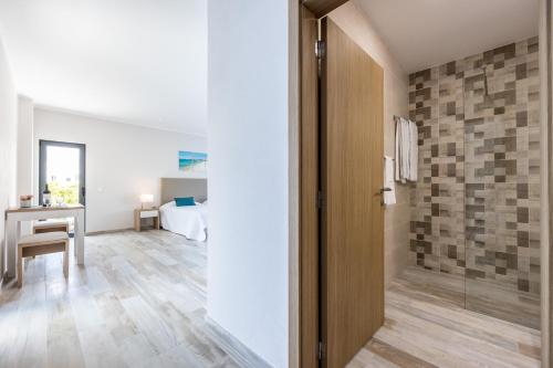 a bathroom with a walkin shower and a table in a room at CASA DAS PRAIAS in Lagos