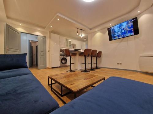 una sala de estar con un sofá y una mesa en Magnifique Appartement Paris La Défense, en Colombes