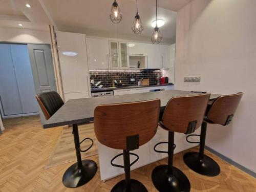 a kitchen with a table and chairs in a kitchen at Magnifique Appartement Paris La Défense in Colombes