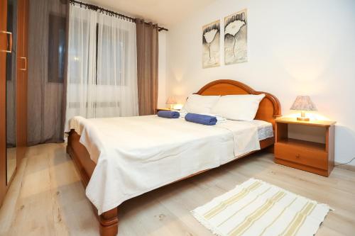 sypialnia z dużym łóżkiem i oknem w obiekcie Pool Apartments Julia w mieście Zadar