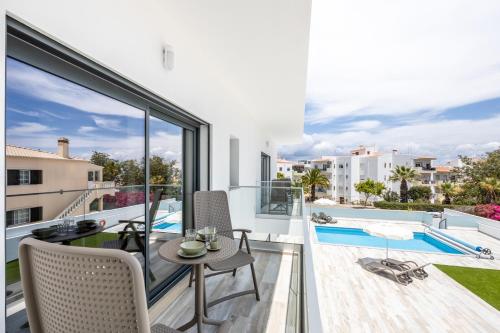 a balcony with a table and chairs and a pool at CASA DAS PRAIAS in Lagos