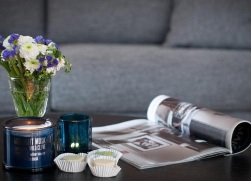 a table with a vase of flowers and a candle at Lindenhof - Sandperle in Wangerooge