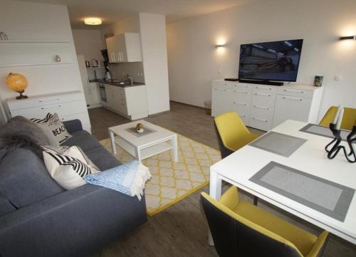 un salon avec un canapé et une table dans l'établissement WoogeBella - Traumblick auf die Nordsee, à Wangerooge