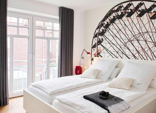 a large white bed in a room with a large window at Miss Evans macht blau in Wangerooge