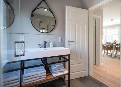 uma casa de banho com um lavatório branco e um espelho. em Lindenhof- Silbermöwe em Wangerooge