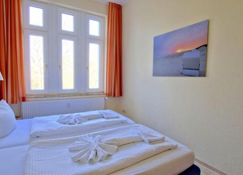 ヴァンガーオーゲにあるFerienwohnung 7 Rosenzweigの窓付きの客室の白いベッド1台