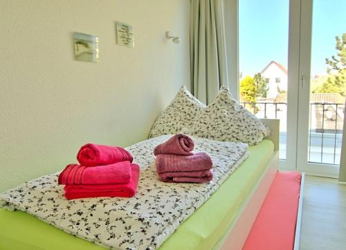 ein Bett mit Handtüchern und einem Fenster in der Unterkunft Strandlust - Anspruchsvolle Ferienwohnung in Wangerooge