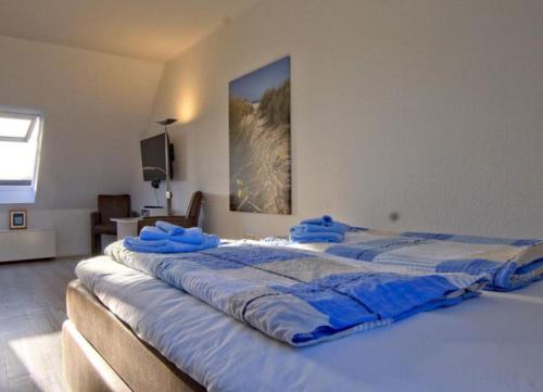 ヴァンガーオーゲにあるMittelpunkt 9 - Zentrales Reihenhaus in perfekter Lageの青い枕が付いたベッドルームの大型ベッド1台