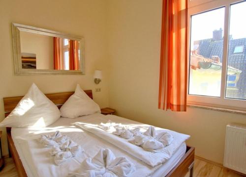 ヴァンガーオーゲにあるFerienwohnung 6 Rosenrotのベッドルーム1室(白いシーツ付きのベッド1台、窓付)
