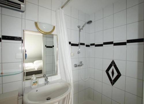 ヴァンガーオーゲにあるStrandhaver - Große Familienwohnung in Strandnäheのバスルーム(シンク、鏡付きシャワー付)