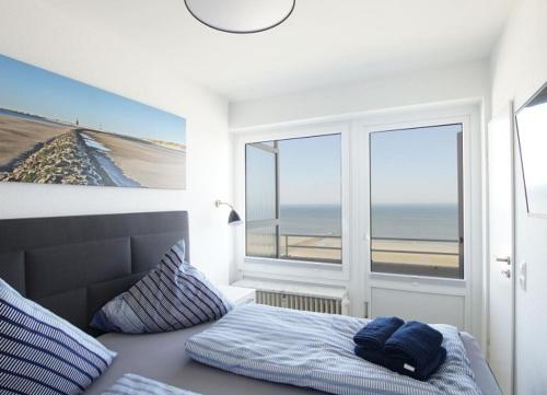 um quarto com uma cama e vista para a praia em Lange Anna em Wangerooge