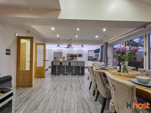 a kitchen and dining room with a table and chairs at Host Liverpool - Greasby Luxury Home, Near Golf & Beach in Greasby