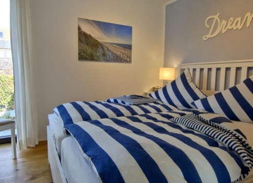 ヴァンガーオーゲにあるWellenspiel - einmalige Atmosphäre mit Rosengartenのベッドルームにベッド2台(青と白のストライプシーツ付)