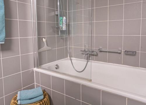 a bathroom with a shower and a tub with a glass door at WangerRose - Familienwohnung für Groß und Klein und Hundefreunde in Wangerooge