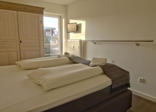 ヴァンガーオーゲにあるRobby 6 - Strandnahe, ruhige Ferienwohnung mit Balkonのベッドルーム1室(白いシーツ付きのベッド1台、窓付)