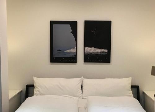 a bedroom with three pictures on the wall above a bed at Robby 7 - Hundefreundliche Terrassenwohnung mit eigenem Garten in Wangerooge