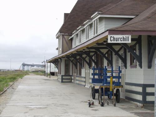 una stazione ferroviaria con sedie blu davanti di Bear Country Inn a Churchill
