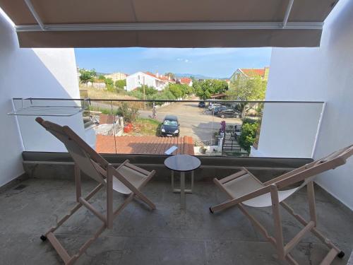 two chairs and a table on a balcony with a view at Momo's House in Nikiti