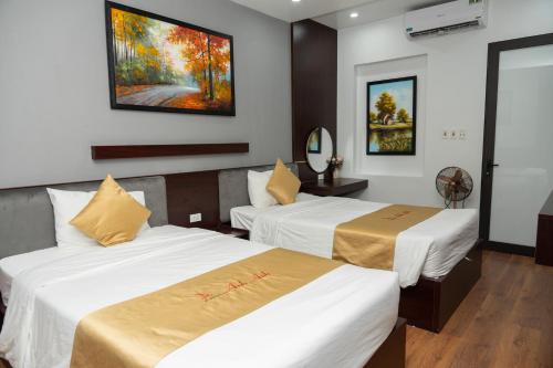 a hotel room with two beds and a painting on the wall at Anh Anh Luxury Hotel in Tuyên Quang