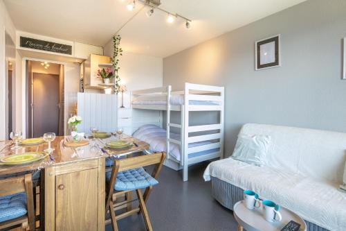 a small room with a bed and a room with a table at Le Freeride - 14ème étage avec vue sur montagne in Villarembert