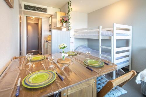 - une salle à manger avec une table et des lits superposés dans l'établissement Le Freeride - 14ème étage avec vue sur montagne, à Villarembert