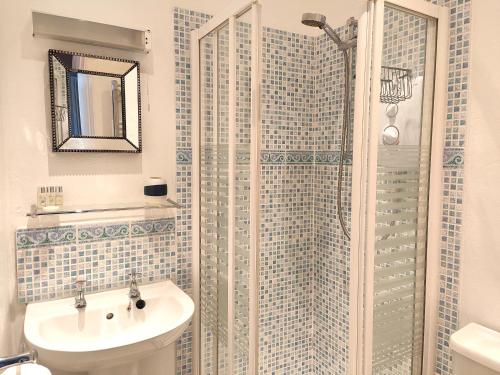 a bathroom with a shower with a sink and a toilet at Squirrel Lodge in Keswick